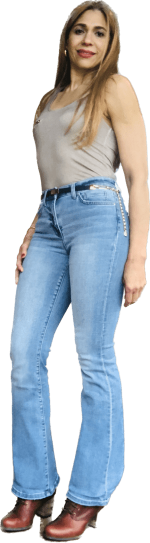 A woman wearing jeans and holding her hand on the side of her leg.