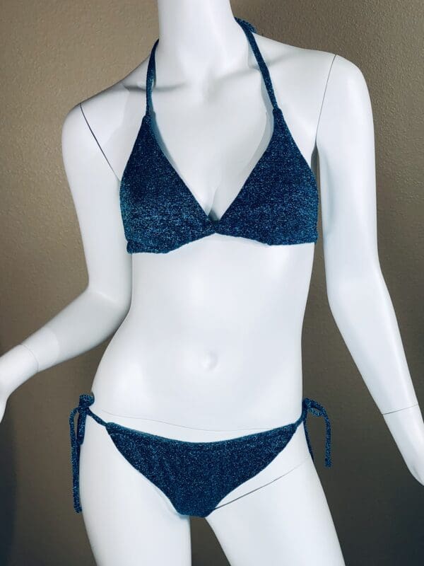 A mannequin wearing a blue bikini with a lace pattern.