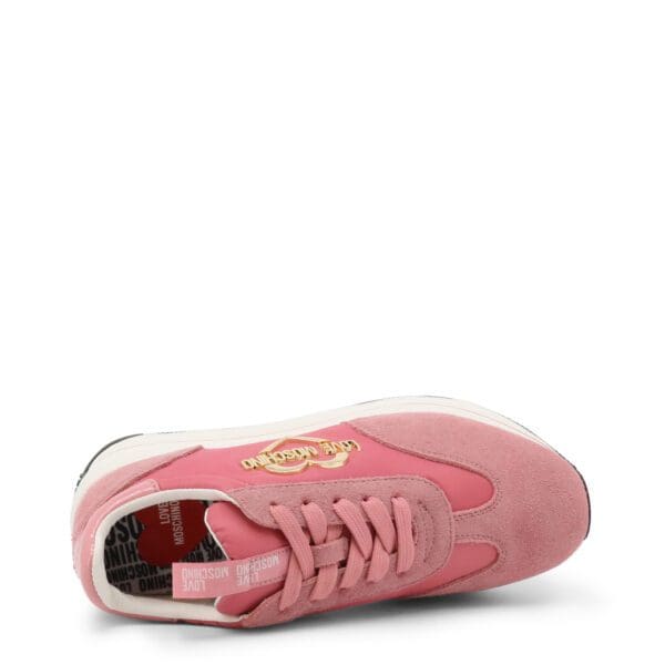 A pink sneaker with a gold logo on the side.