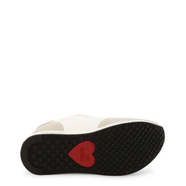 A pair of white shoes with red heart on the sole.