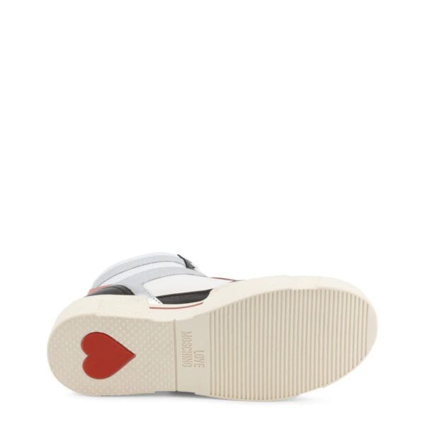 A pair of shoes with red heart on the sole.