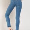A woman wearing blue jeans and black heels.