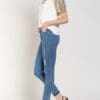 A woman wearing jeans and heels standing up.
