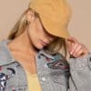 A woman in yellow hat and jean jacket.