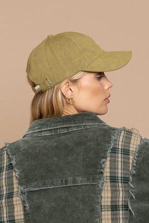 A woman wearing a hat and plaid shirt.