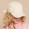 A woman wearing a hat and pink jacket.