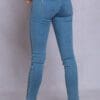 A woman wearing blue jeans and white shoes.