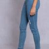 A woman wearing blue jeans and white shoes.