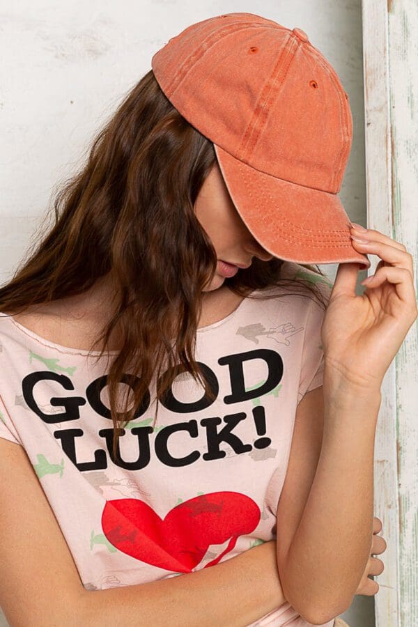 A woman wearing a hat and saying " good luck ".