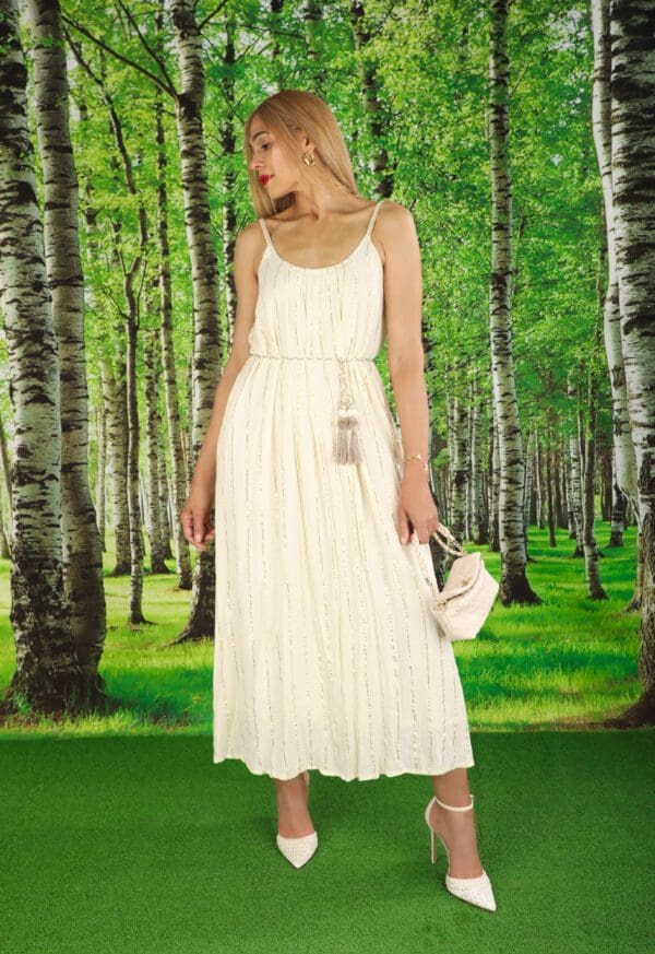 A woman in white dress standing next to trees.