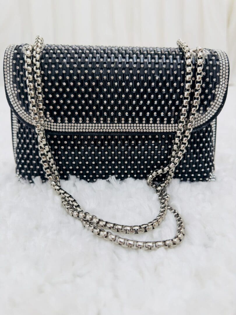 A black purse with silver and white polka dots.