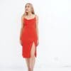 A woman in red dress standing on one leg.