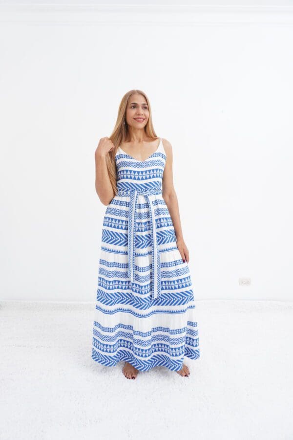 A woman in blue and white dress standing on the floor.