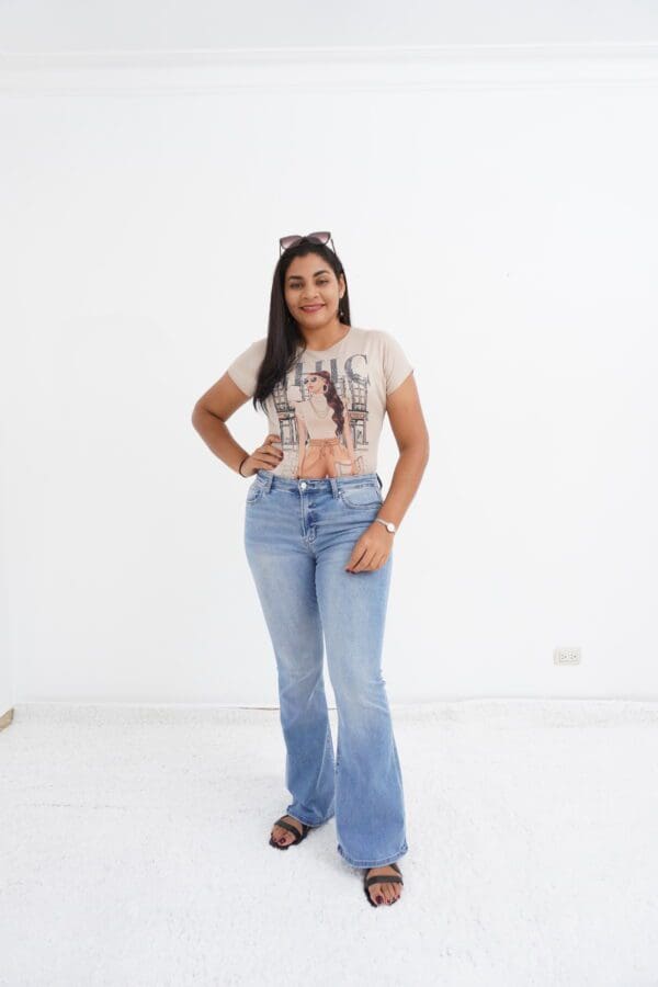 A woman standing in front of a white wall.