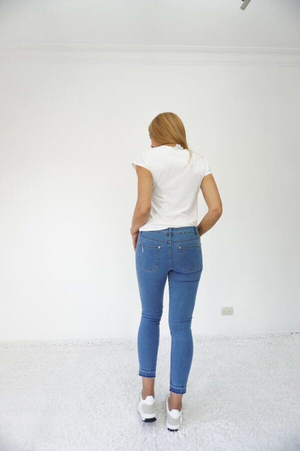 A woman standing in front of a white wall.