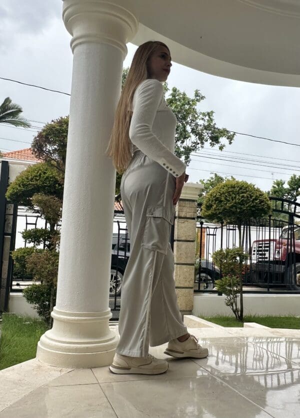 A woman standing on top of a white pillar.