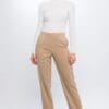 Woman in beige pants and white top.