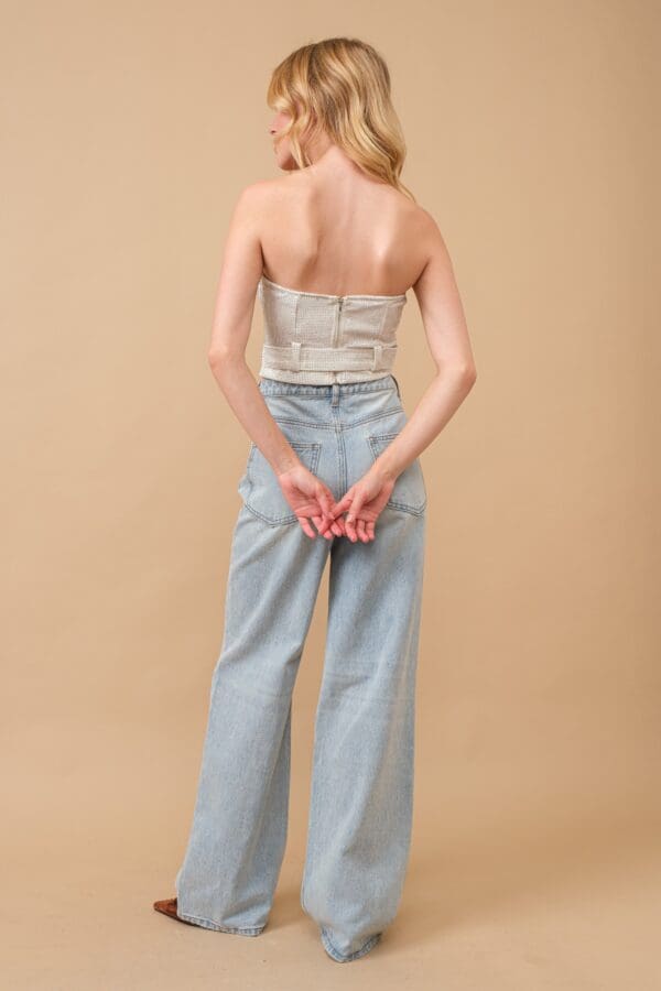 Woman in white corset and jeans.