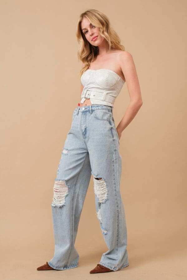 Woman in white top and distressed jeans.