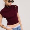 Woman in burgundy knit top and jeans.