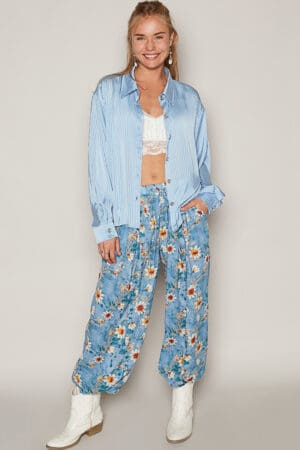 Woman in blue shirt and floral pants.