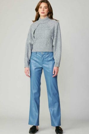 Woman in grey sweater and blue pants.