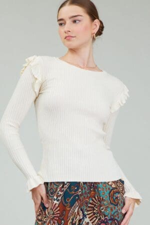 Off-white ribbed knit top with ruffles.